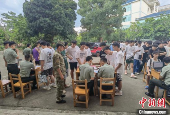 专武干部在发放兵役登记证。 韦硕 摄