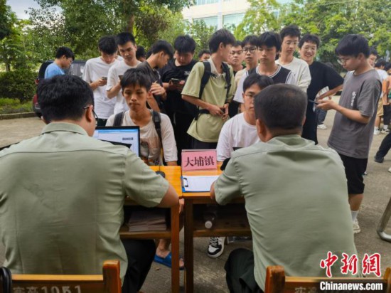 专武干部在发放兵役登记证。 韦硕 摄