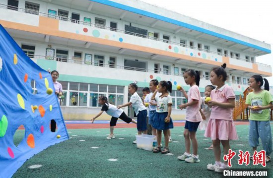 在肥西县山南镇中心幼儿园，孩子们在玩布洞投球游戏。　陈家乐 摄