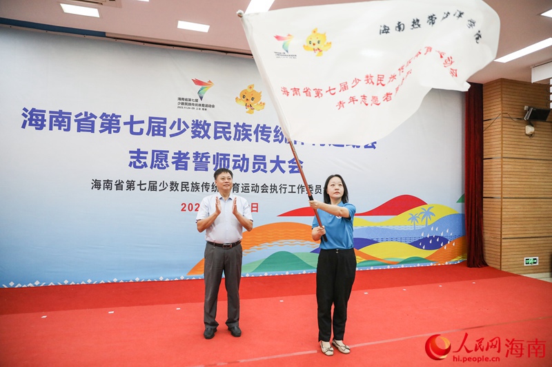 图：张长丰为海南热带海洋学院志愿者服务队授旗。人民网记者 牛良玉摄