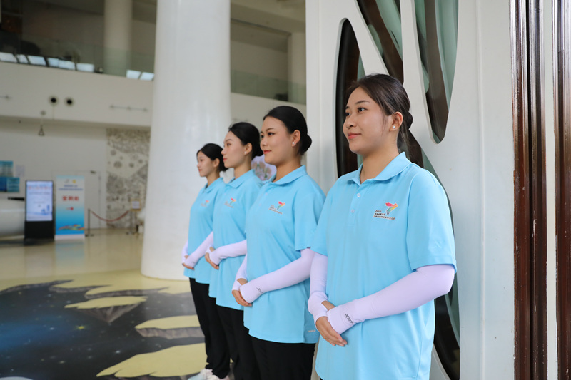 志愿者们在酒店大堂门口微笑迎客。人民网记者 牛良玉摄