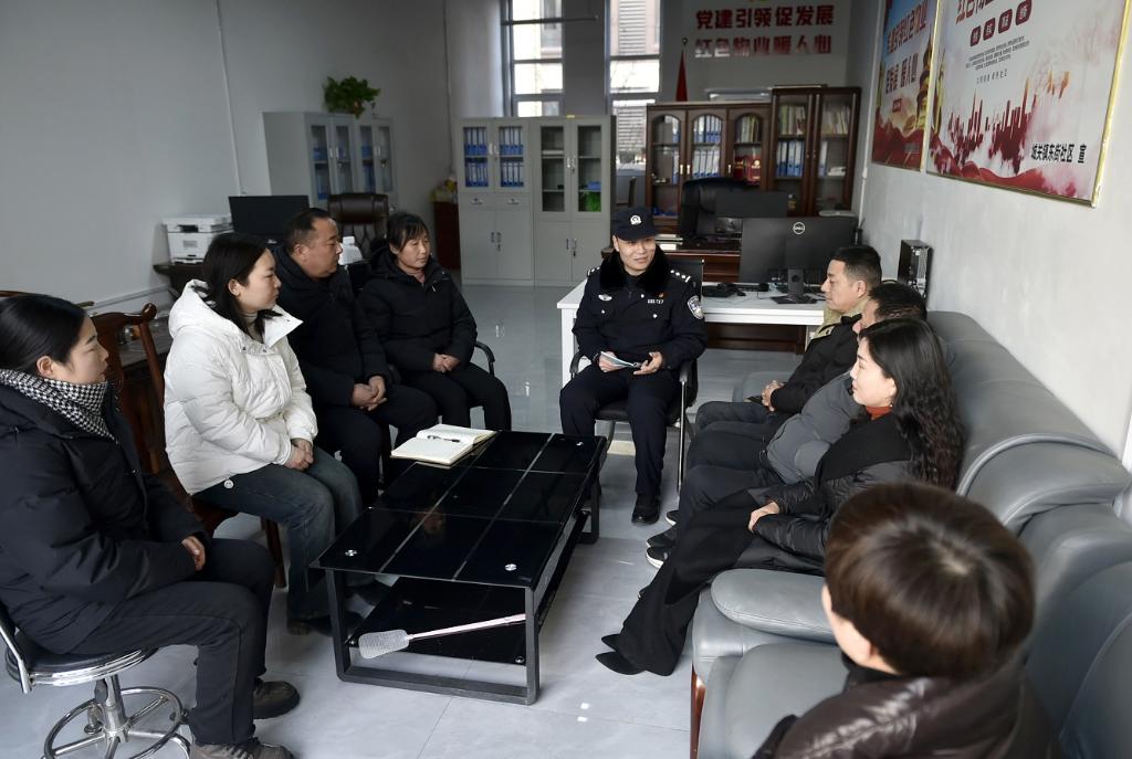 2023年12月20日，在河南省宝丰县城关镇东街社区红色物业服务中心，社区民警向居民介绍防范电信诈骗知识。 新华社记者 鲁鹏 摄