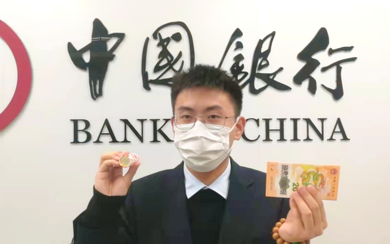 客户展示兑换的龙年纪念币、纪念钞。王玫摄