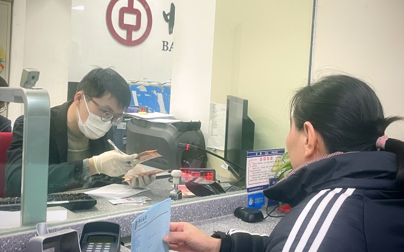 银行工作人员为客户兑换龙年纪念钞。王玫摄