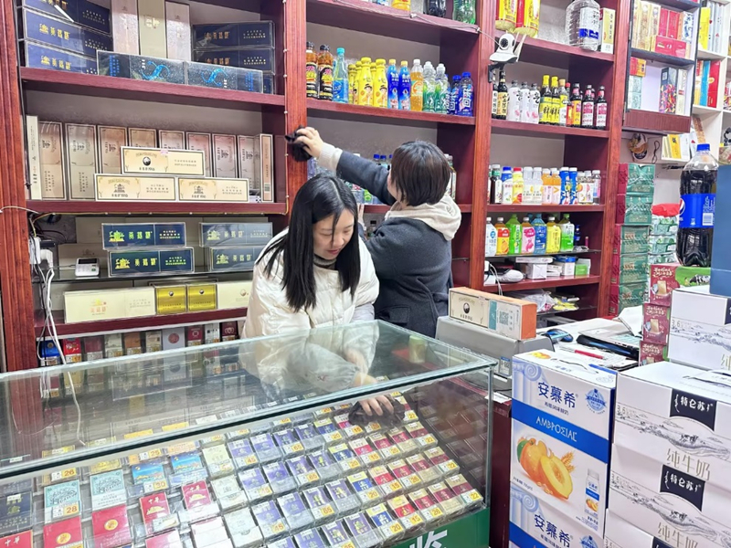 志愿服务队队员在帮助李良艳家整理柜台、打扫卫生。
