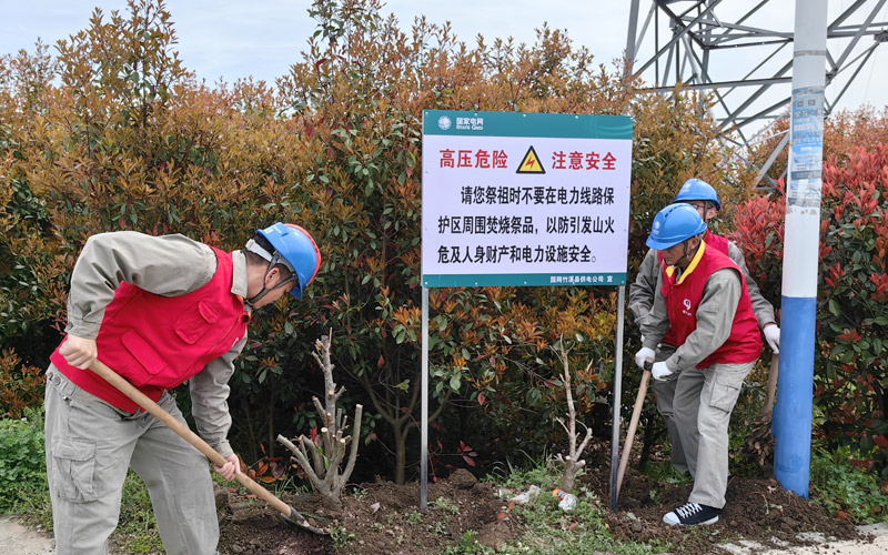 3月29日，国网竹溪县供电公司中峰供电所“鄂电红马甲”在线路下方安装防山火警示牌。柯勇摄