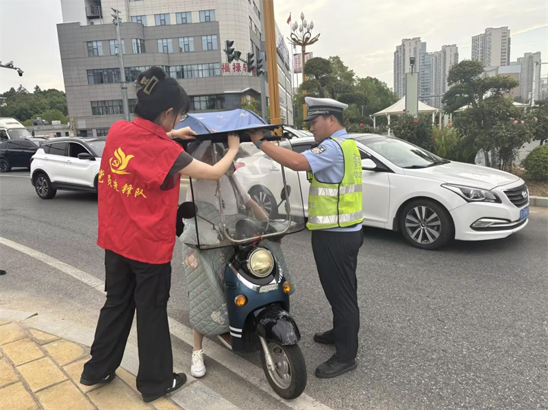 青年员工协助交警开展文明交通劝导。