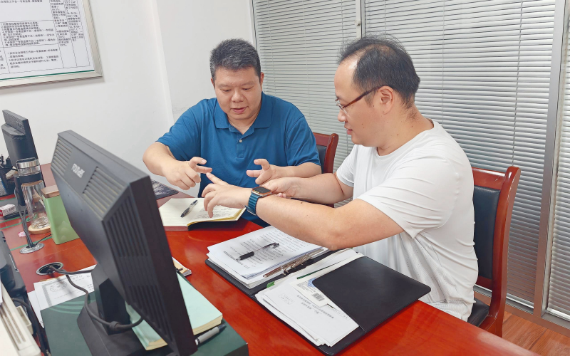 青年员工正在讨论比划，调试绘图尺实际勘察适配度。张沛供图