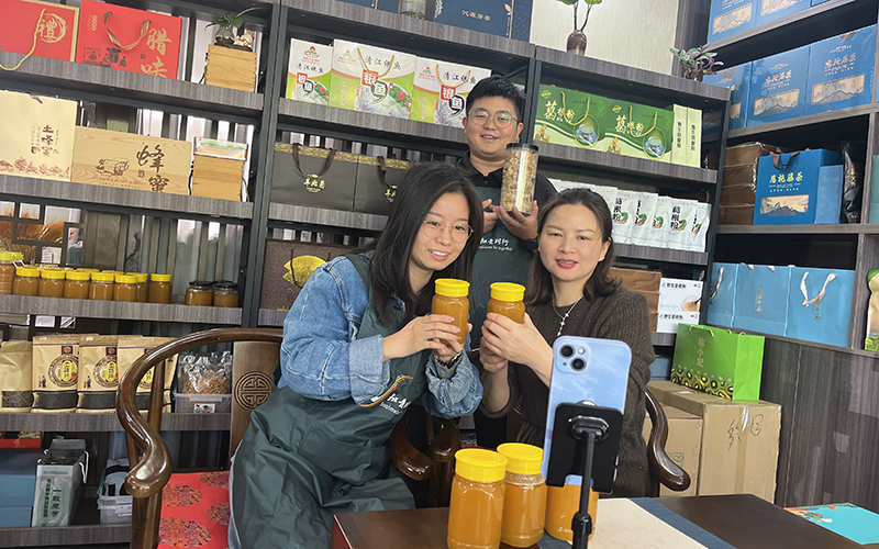 零售户（右）在客户经理的指导下学习直播带货。